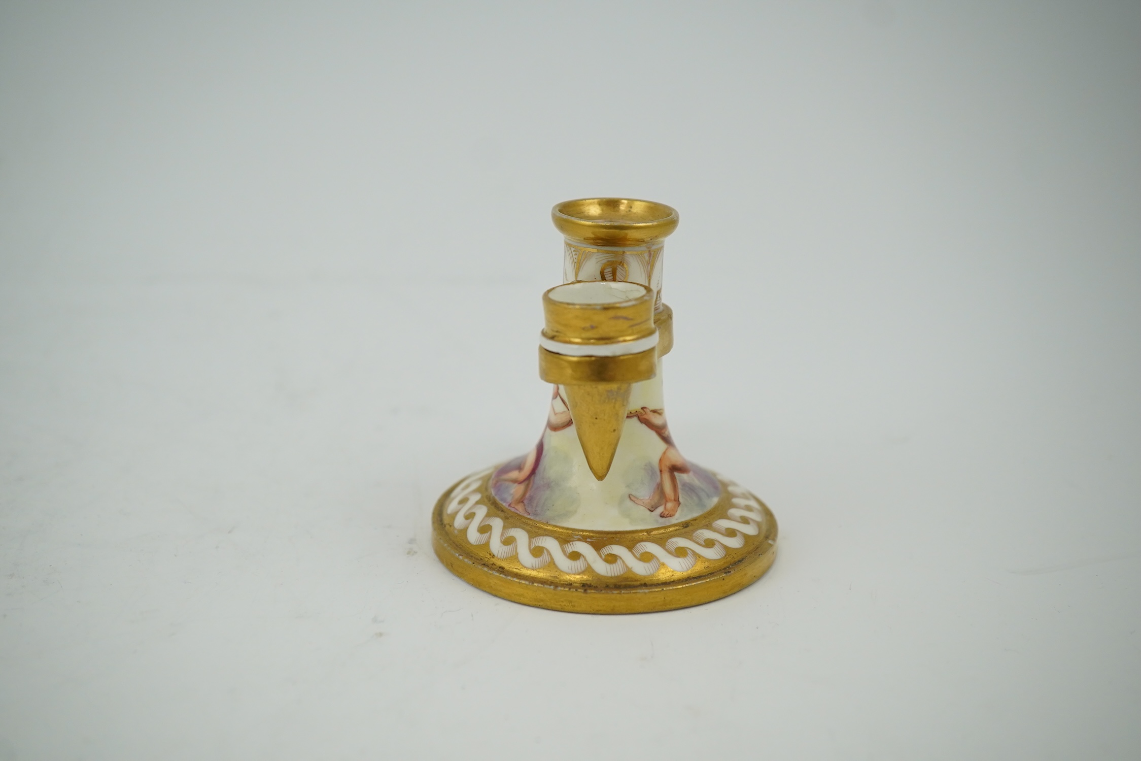 An early 19th century English or French porcelain chamberstick with extinguisher, 7cm high. Condition - extinguisher cracked, chamberstick good